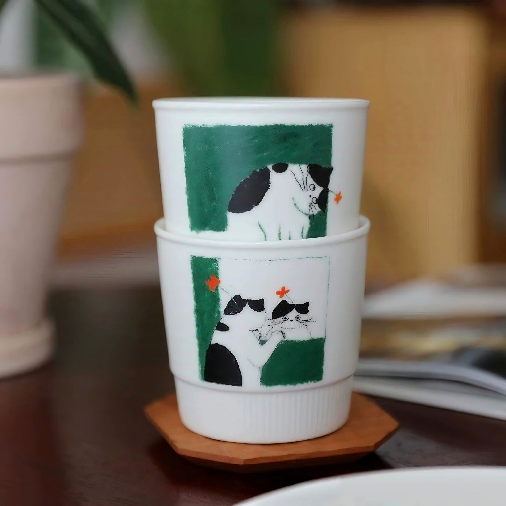 Cute ceramic cup with a hand-painted illustration of a kitten gazing at itself in the mirror. Artistic coffee mug featuring a dreamy kitten looking up in wonder, rendered in hand-painted underglaze style. A joyful sketch mug ideal for self-care moments, gift for girls, or soft Nordic interiors.