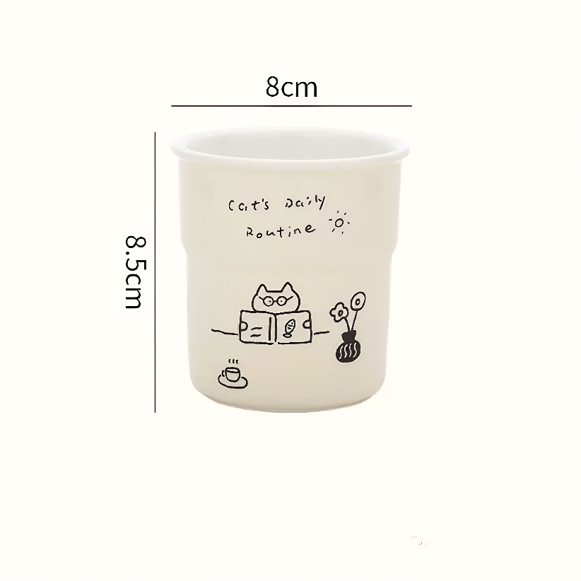Cute ceramic coffee mug with playful hand-painted kitten reading a book, crafted in durable underglaze ceramic. Great for cozy moments and slow mornings with tea or coffee.