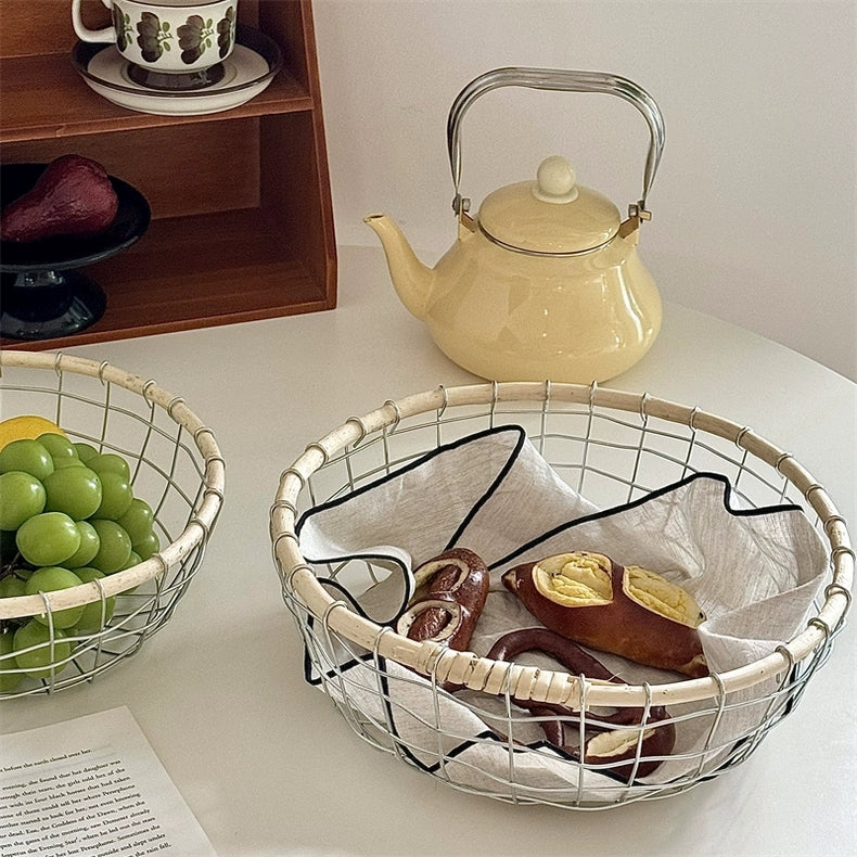 Eco-friendly metal and rattan basket filled with colorful fruits and breads, ideal for Scandinavian style kitchens.