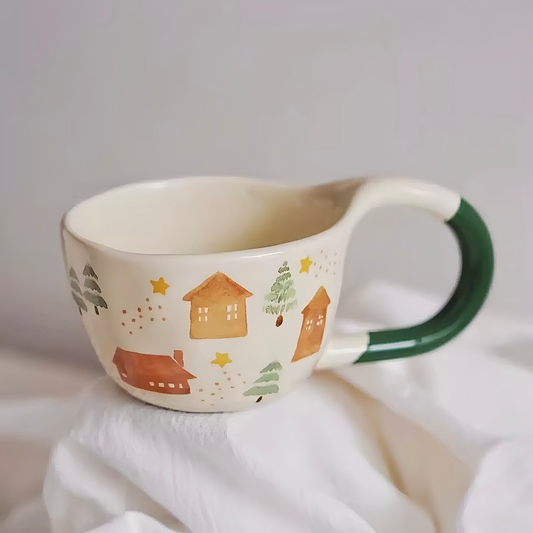 Rustic artisan-style ceramic cup featuring sweet winter house details. Hand-painted, durable, microwave and dishwasher safe.