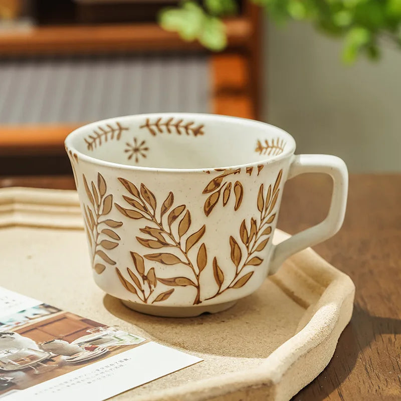 Close-up of a ceramic mug featuring a delicate bean leaves pattern, showcasing its textured finish and neutral color palette.