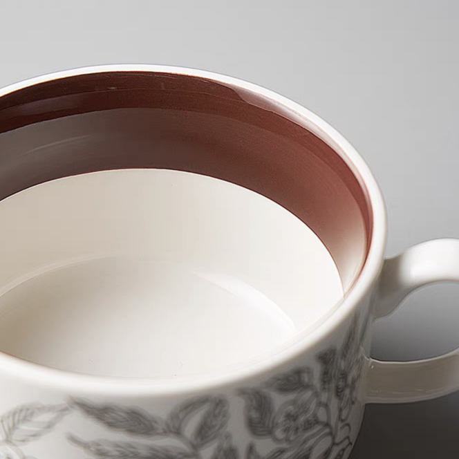 A minimalist ceramic mug with a matching saucer, featuring smooth finish and vibrant colour.