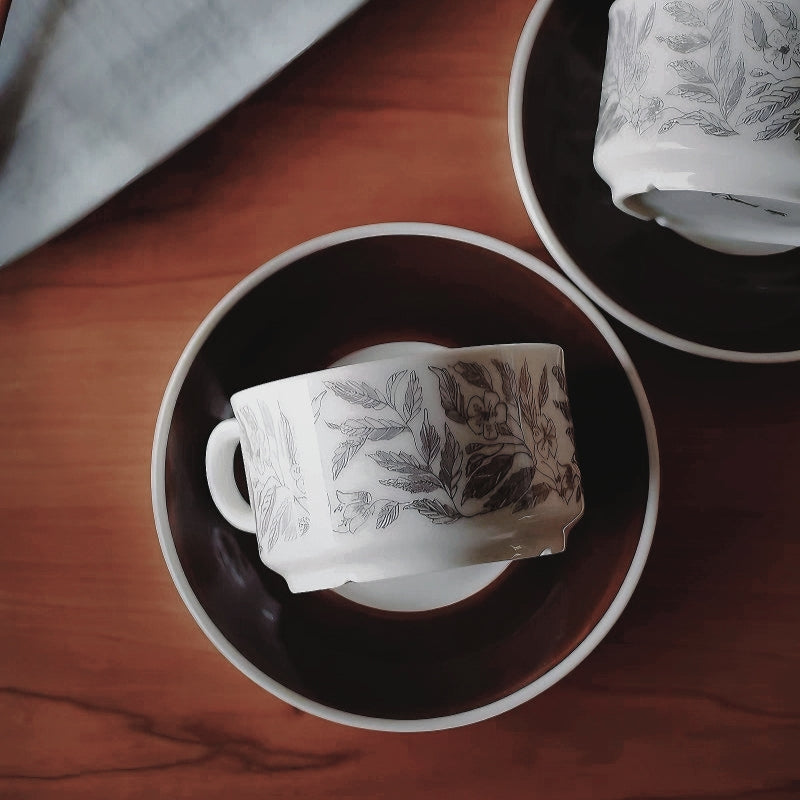 A minimalist ceramic mug with a nature-inspired brown leaf design, paired with a saucer for cozy drinks. Capacity of 220 ml/ 7.4 oz.