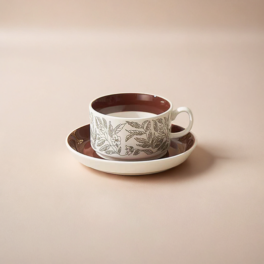 A minimalist ceramic mug with a nature-inspired brown leaf design, paired with a saucer for cozy drinks. Capacity of 220 ml/ 7.4 oz.