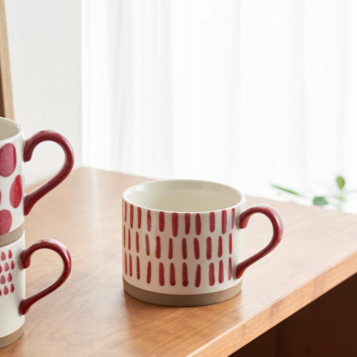 Contemporary ceramic mug with a hand-drawn red design, suitable for festive or casual use.