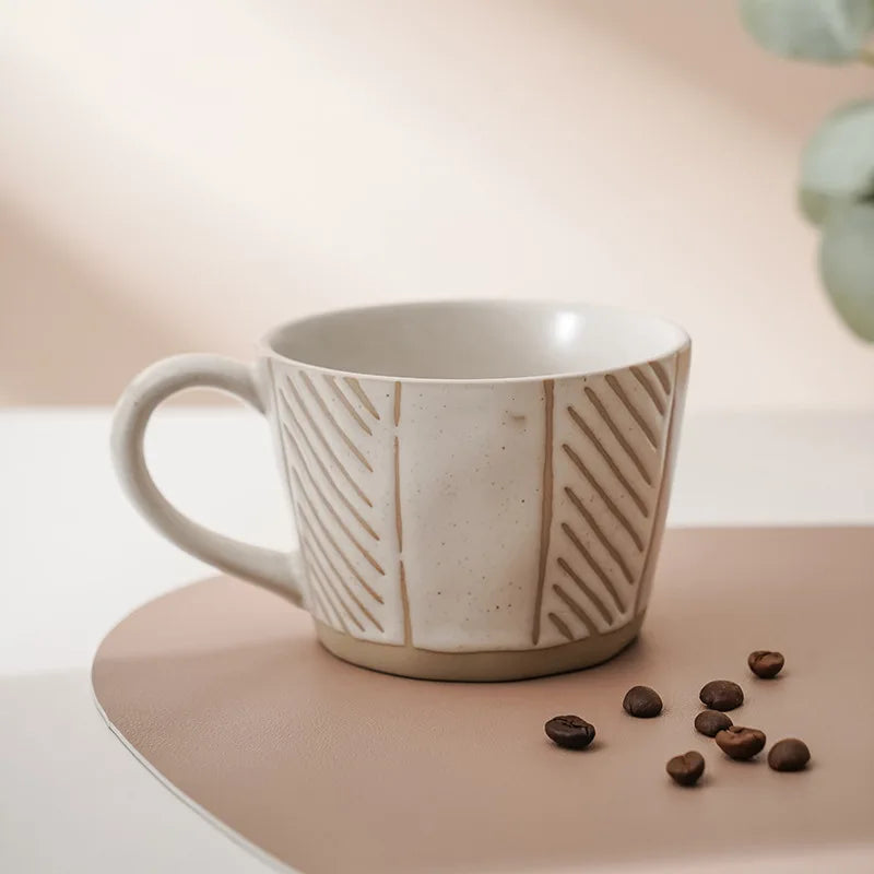 A ceramic cup featuring a minimalist, neutral-toned pattern, ideal for coffee lovers who appreciate Nordic design.
