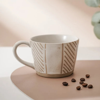 A ceramic cup featuring a minimalist, neutral-toned pattern, ideal for coffee lovers who appreciate Nordic design.