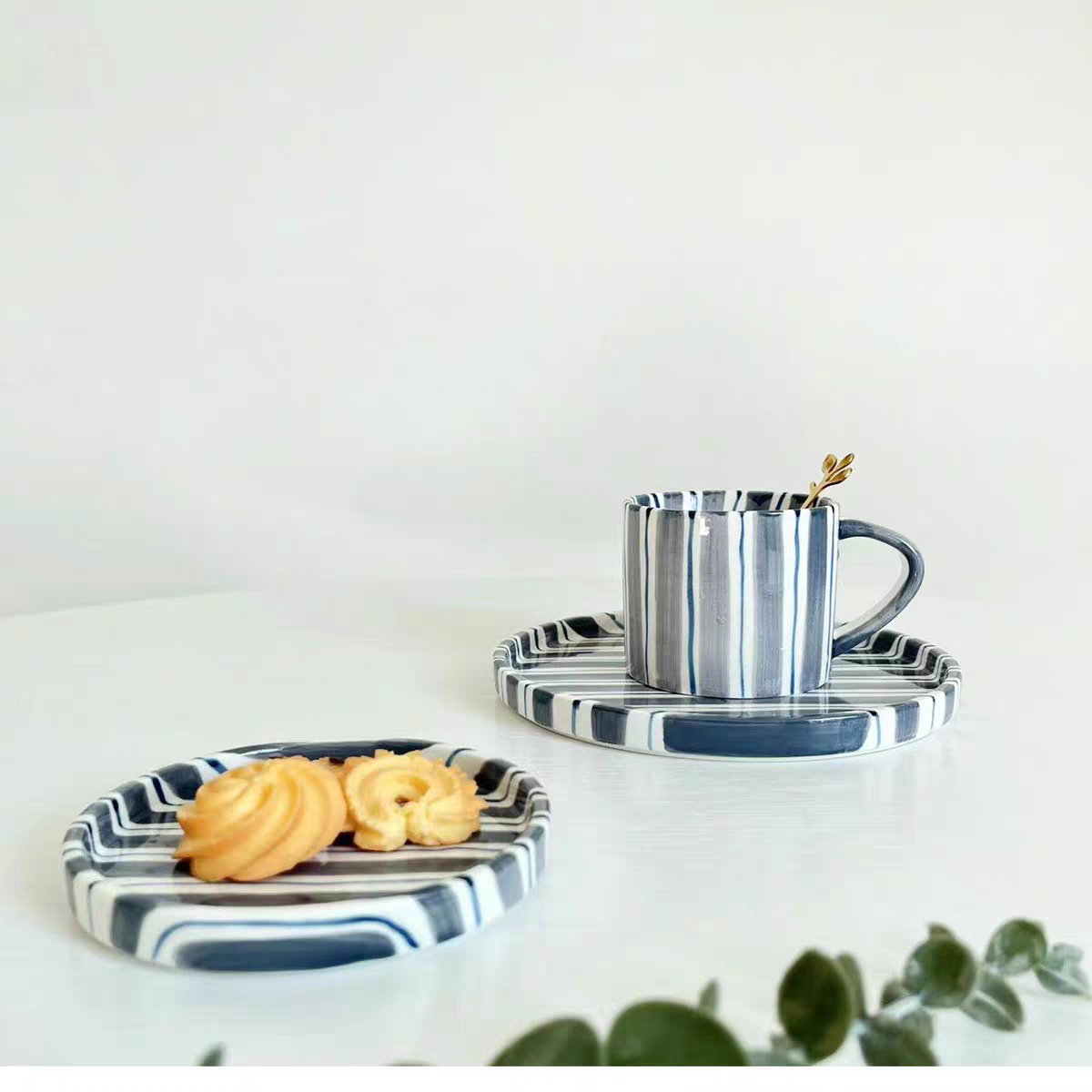 Durable ceramic cup and plate set with hand-painted cerulean blue stripes, ideal for coffee, tea and beverages, microwave and dishwasher safe.