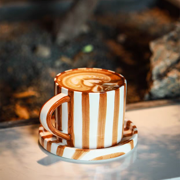 Vibrant burnt orange striped ceramic cup and plate set, ideal for Scandinavian-style dining, serving coffee, tea, cakes, and appetizers.