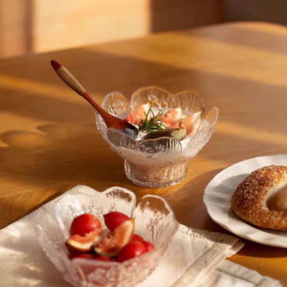 Pedestal-style glass dessert bowl holding yogurt with toppings, highlighting its clear material and embossed floral pattern.