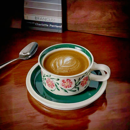 A ceramic cup with floral motifs in vibrant colors, ideal for coffee or tea, featuring eco-friendly materials and a smooth glaze finish.
