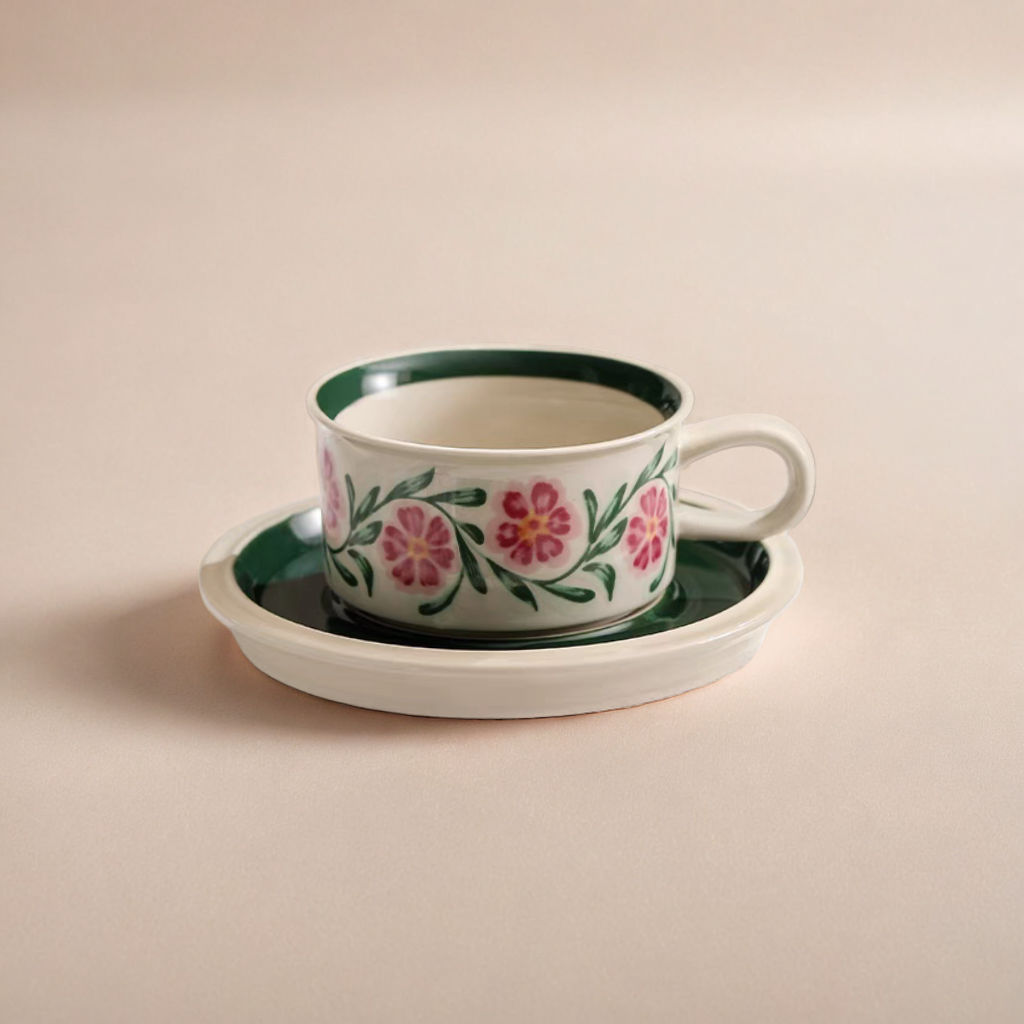 A ceramic cup with floral motifs in vibrant colors, ideal for coffee or tea, featuring eco-friendly materials and a smooth glaze finish.