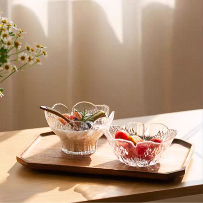 Transparent glass bowl featuring a petal design, filled with colorful fresh fruits, ideal for modern and Scandinavian dining. Microwave and dishwasher save.