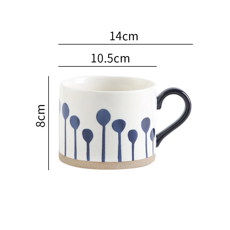 Cream-white ceramic mug with delicate blue floral motifs, ideal for coffee and tea lovers.