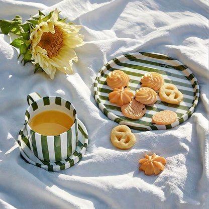 Modern ceramic cup with hand-painted green grass stripes, featuring a minimalist Scandinavian design and ergonomic handle, perfect for hot beverages.