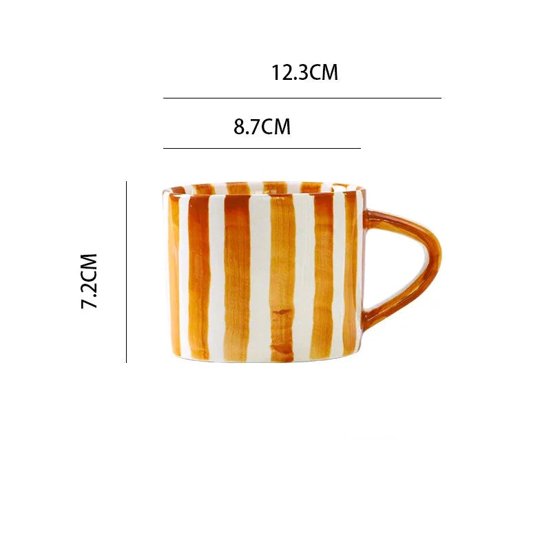 Modern ceramic cup with ergonomic handle and vibrant burnt orange stripes, perfect for serving coffee, tea, or any hot beverage in Scandinavian style.