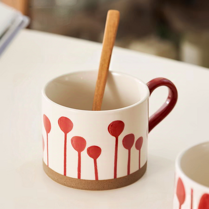 Hand-painted ceramic mug featuring a unique red balloon pattern and earthy base, ideal for modern kitchens.