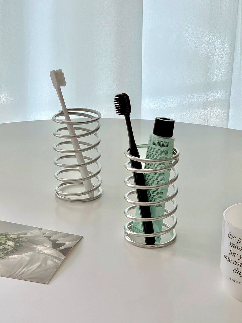 Practical and stylish brush holder for bathroom countertops, providing a neat storage solution for makeup brushes and toothbrushes.