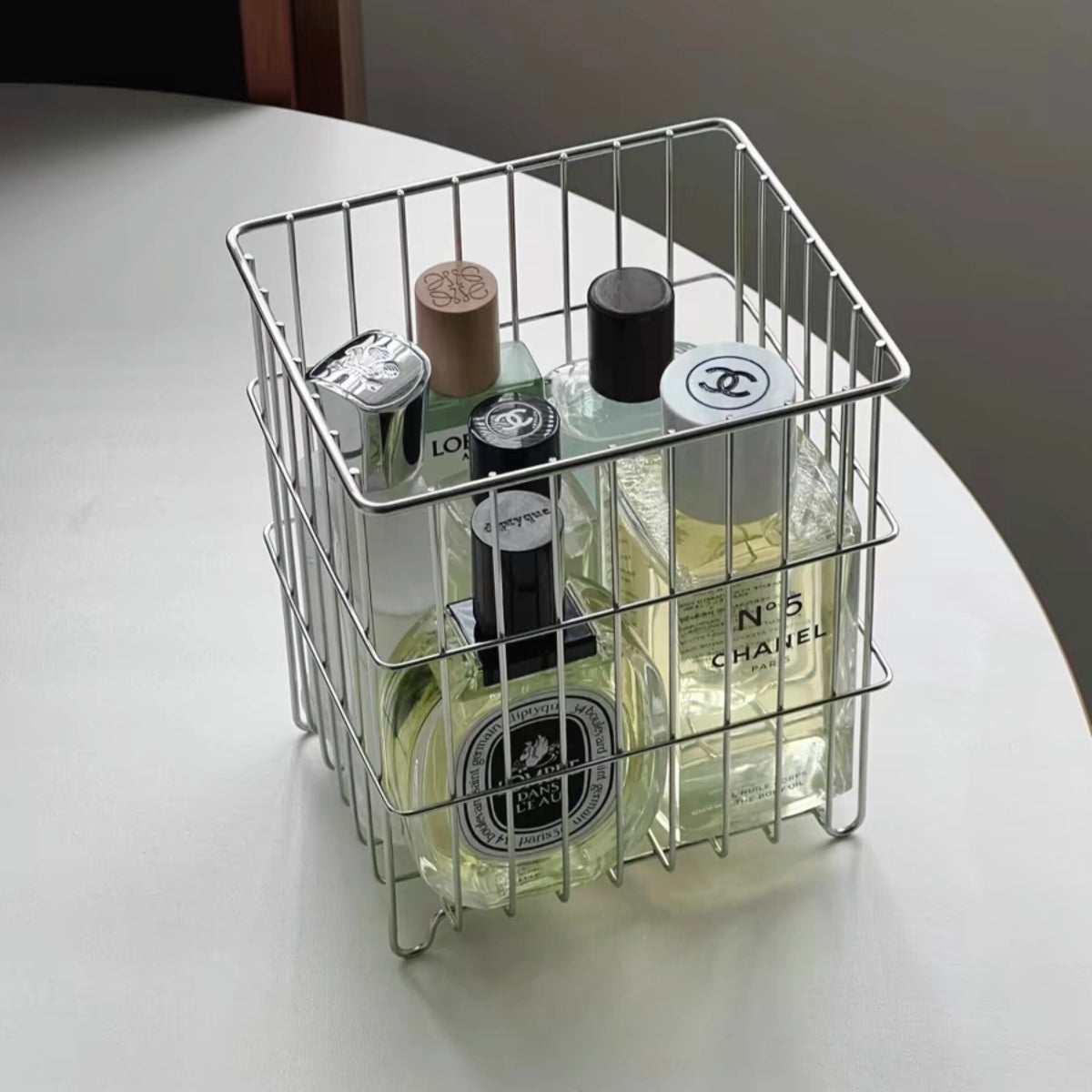 Stylish metal wire basket used for storing perfumes in the bedroom.Elevate your organization with this decorative metal wire basket, featuring an elegant design that enhances any space with its modern aesthetic.