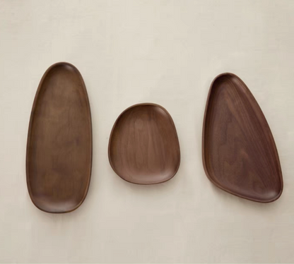 Full view of the irregular shaped solid wood serving tray in walnut wood color, highlighting the eco-friendly, handmade craftsmanship and unique shape, suitable for classic, Japandi, and Nordic-inspired interiors.