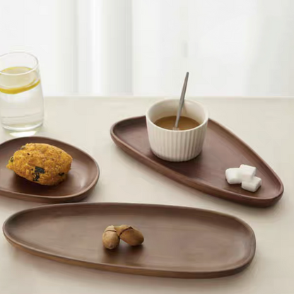 Irregular shaped solid wood serving tray in walnut wood color, holding assorted desserts for afternoon tea, showcasing eco-friendly and handmade craftsmanship.