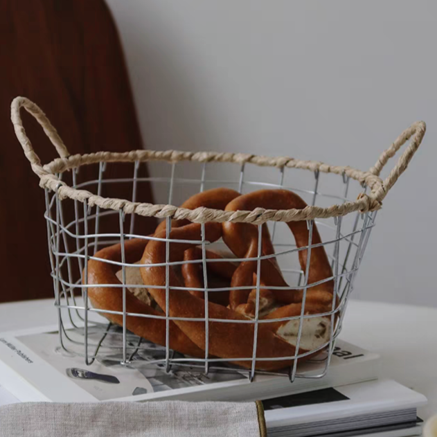 Handmade woven metal wire basket holding fresh bread, highlighting its functional and decorative appeal in a natural-inspired kitchen.