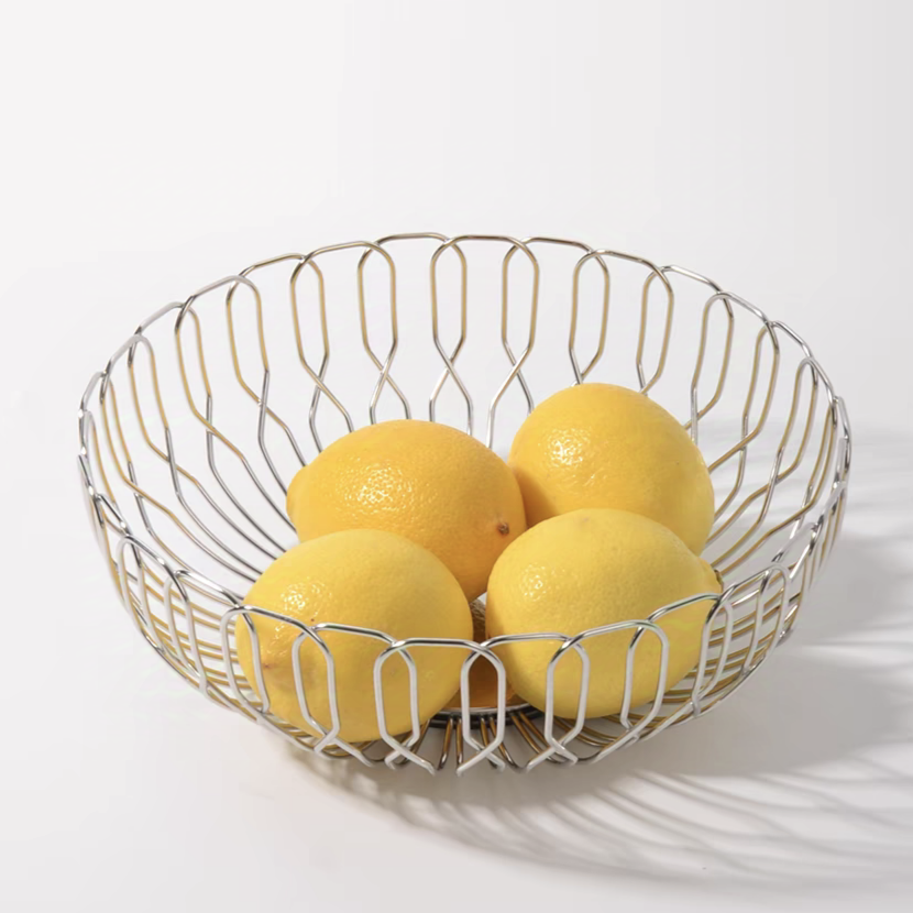 A shiny stainless steel fruit basket holding bright yellow lemons, perfect for contemporary kitchen decor.