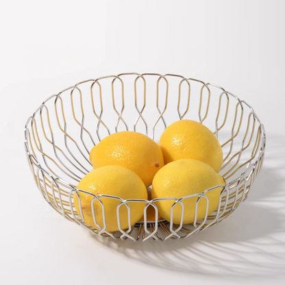 A shiny stainless steel fruit basket holding bright yellow lemons, perfect for contemporary kitchen decor.