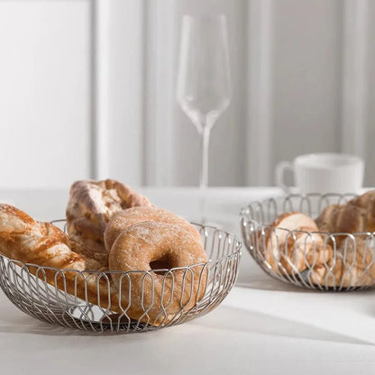 Stainless steel basket used as a bread holder, perfect for serving fresh bread on your countertop or dining table.