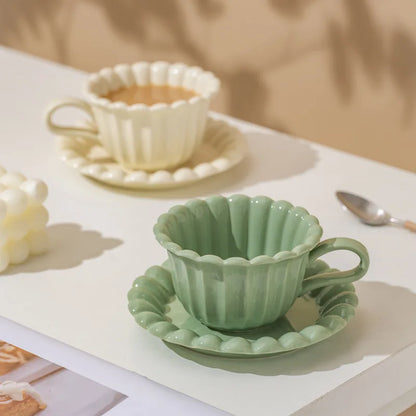 Matching cream white and light green floral ceramic coffee cup and plate set for tea, latte, or hot drinks.