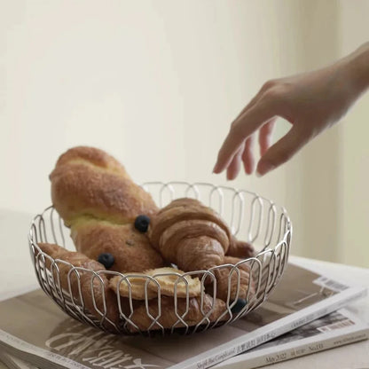 Stainless steel basket filled with rolls, showcasing its contemporary, easy-to-clean design for everyday kitchen use.