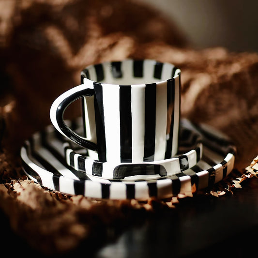 A modern ceramic cup, featuring hand-painted black stripes. This minimalist Scandinavian-inspired mug is perfect for stylish, contemporary dining occasions.