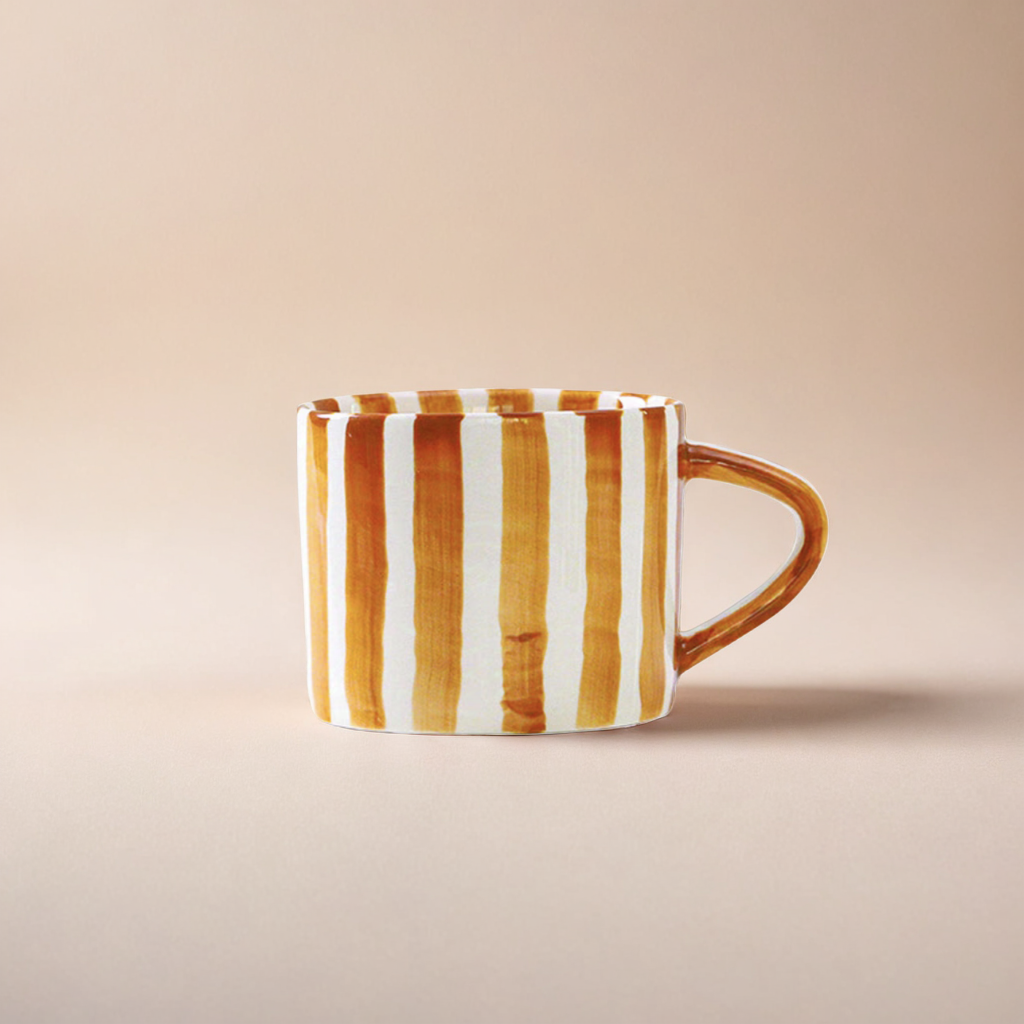 Modern ceramic cup with bold burnt orange stripes, blending Scandinavian minimalism with stylish functionality for any table setting.