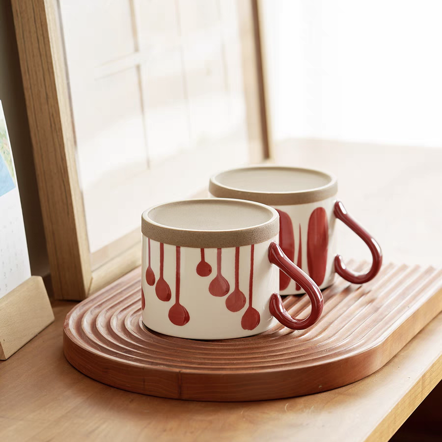 A collection of artisan ceramic cups featuring bold red abstract patterns, ideal for minimalist and Japandi interiors.