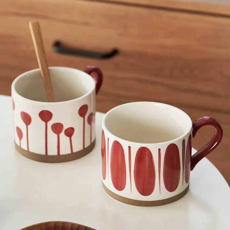 A collection of artisan ceramic cups featuring bold red abstract patterns, ideal for minimalist and Japandi interiors.