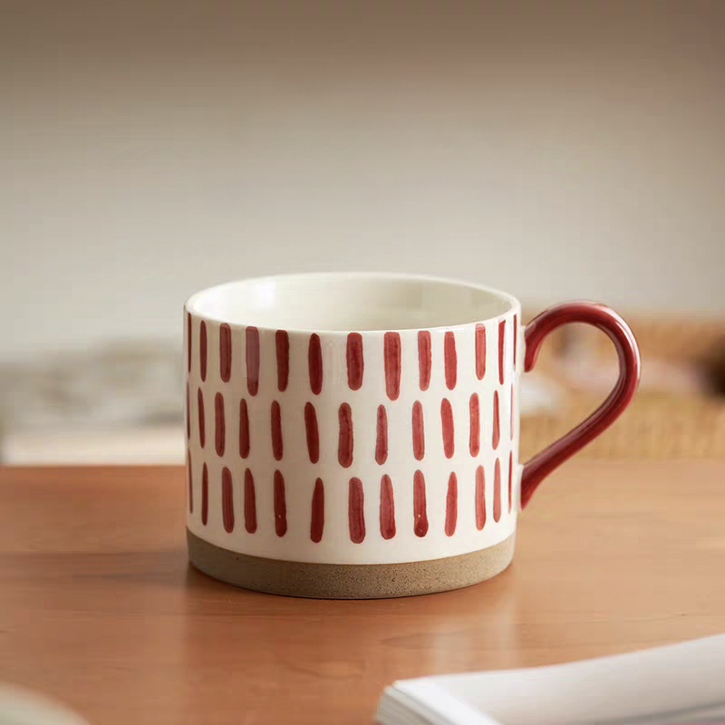 Handcrafted ceramic mug with striking geometric red patterns, ideal for coffee, tea, and decor.