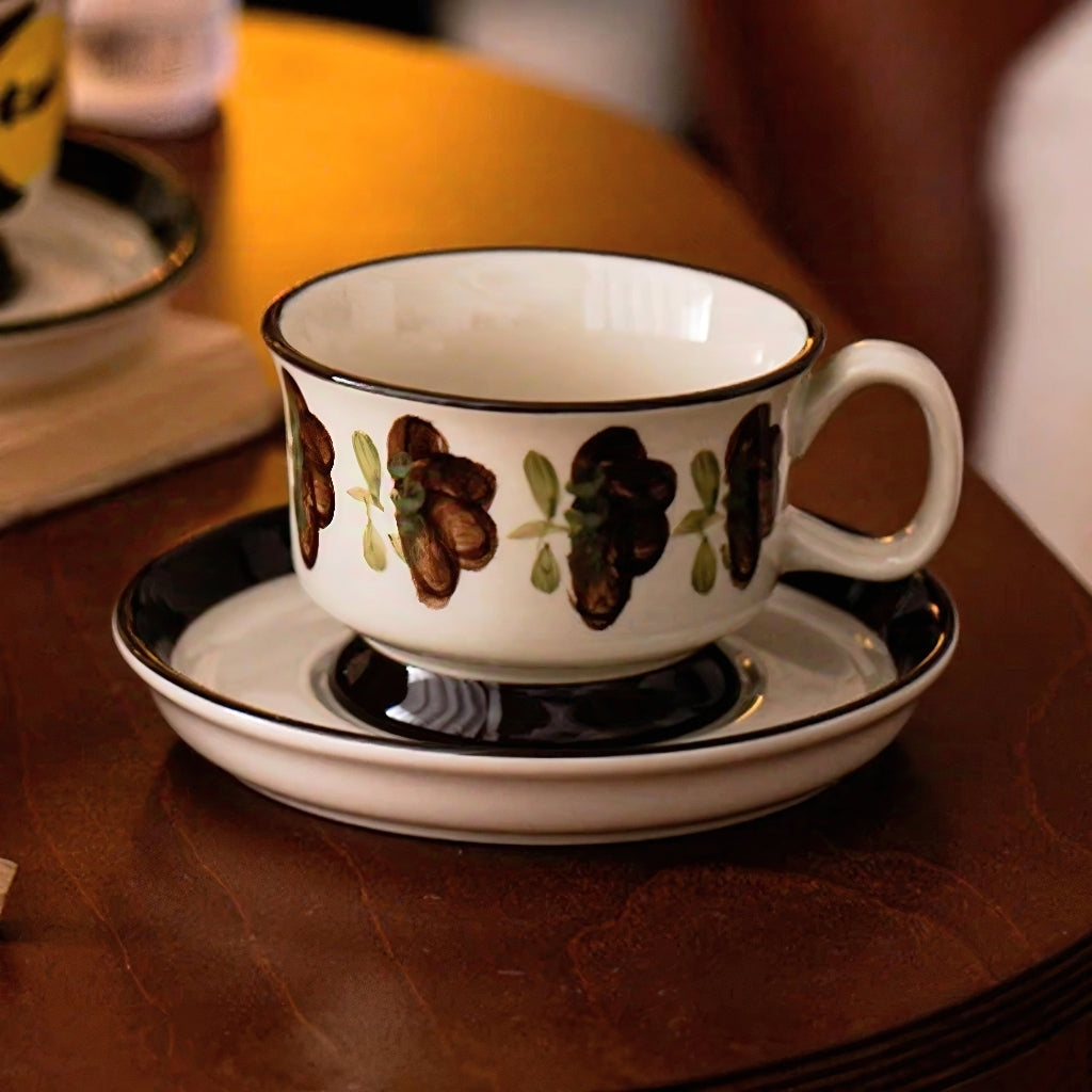 Ceramic cup resting on a 14.3 cm (5.63 inches) saucer with hand-painted vintage grape pattern, ideal for coffee and tea.