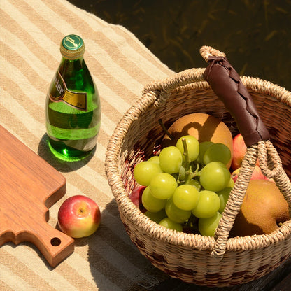 Eco-friendly seaweed basket filled with fruits at a picnic, offering sustainable, stylish storage for outdoor dining.