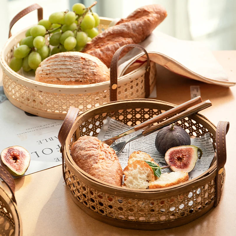 Two round rattan wicker trays, one in natural wood and one in walnut wood, filled with snacks and fruits, illustrating the different size options and convenient leather handles for carrying.