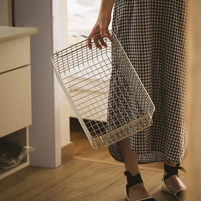 Sleek stainless steel storage basket with handles, designed for easy transport. Made from durable metal, suitable for multiple home decor styles.