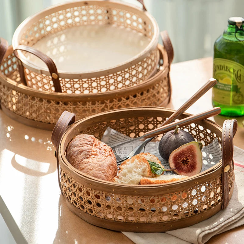 Round wicker storage tray in walnut wood color or natural wood colour, holding assorted bread, highlighting the durable leather handles and the availability in various sizes.