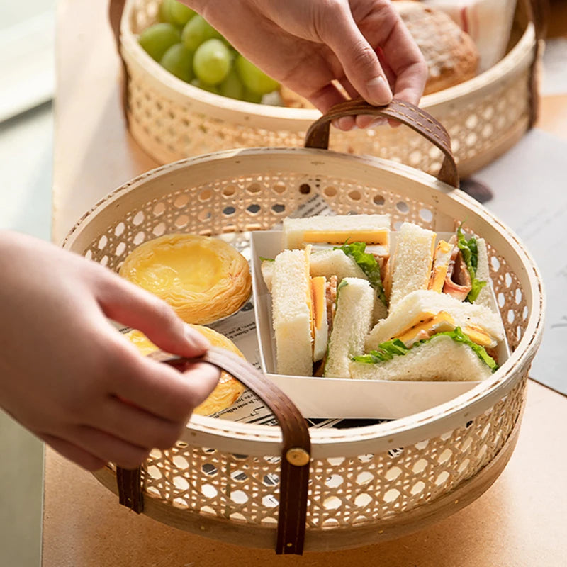 Eco-friendly round rattan wicker tray with leather handles, filled with snacks, shown in natural wood colors, emphasizing easy mobility and multiple sizes.