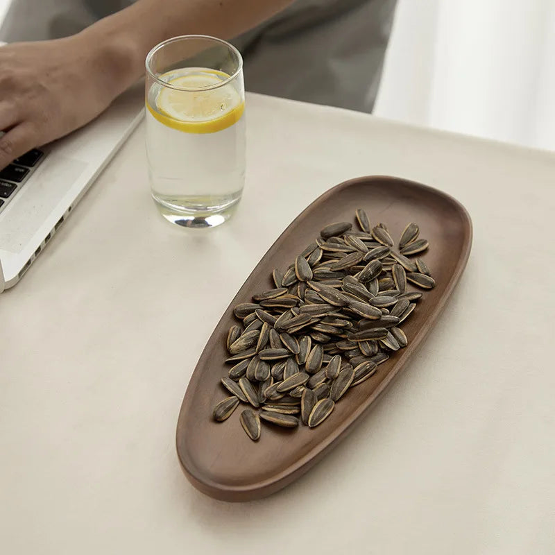 Irregular-shaped solid wood tray holding a variety of snacks, featuring the durable walnut wood construction and handmade craftsmanship.