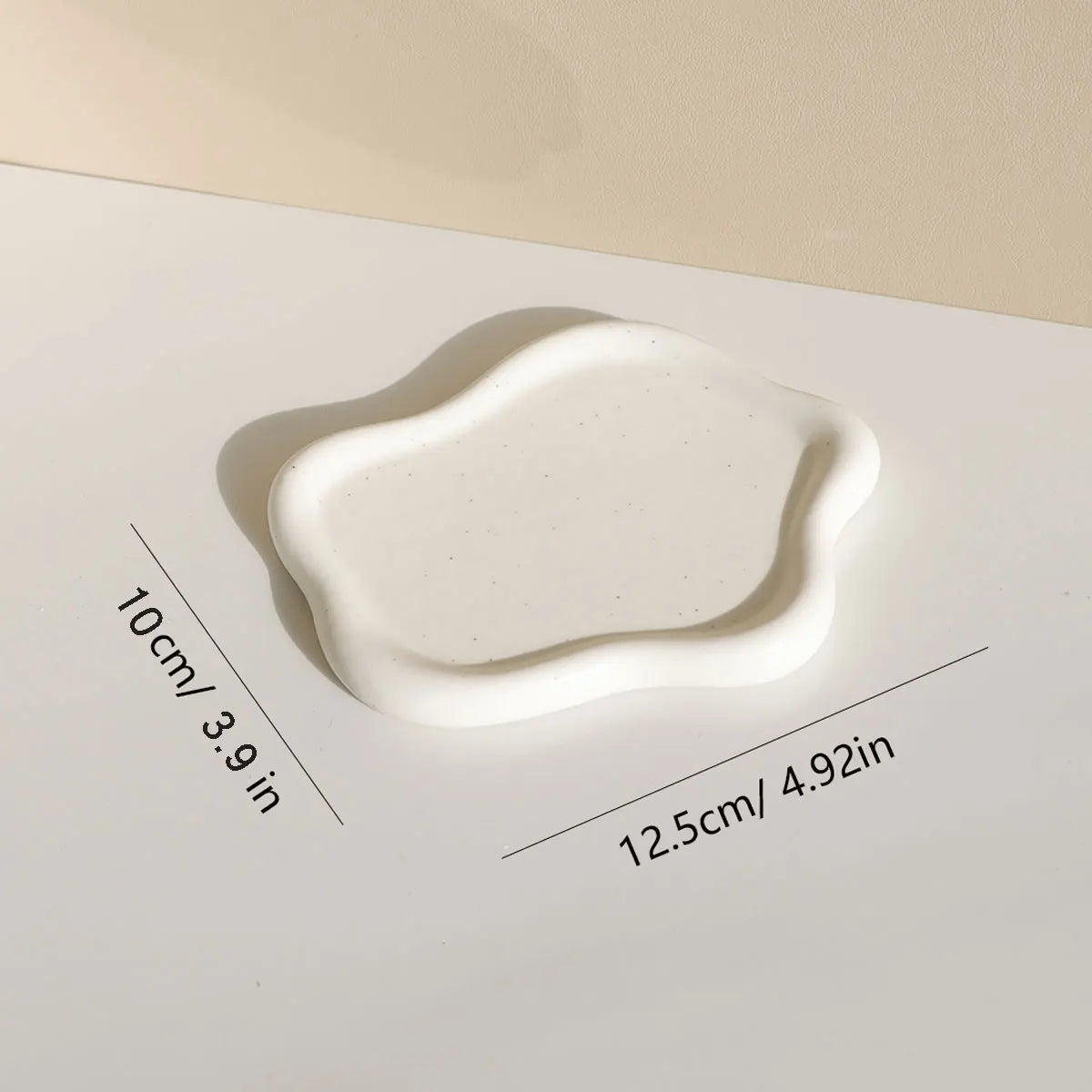 White cloud-shaped ceramic tray on a countertop, demonstrating its stylish appearance and practical size for organizing small items in modern interiors.