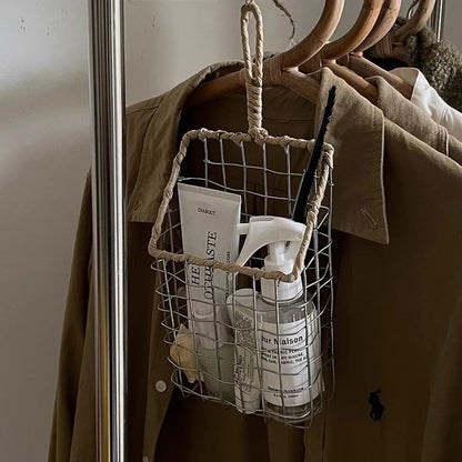 Metal wire basket hanging in closet, holding fragrances, adding a natural-inspired touch.