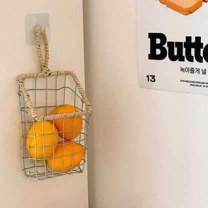 Decorative woven storage basket hanging in the kitchen, filled with vegetables, showcasing Scandinavian minimalism.