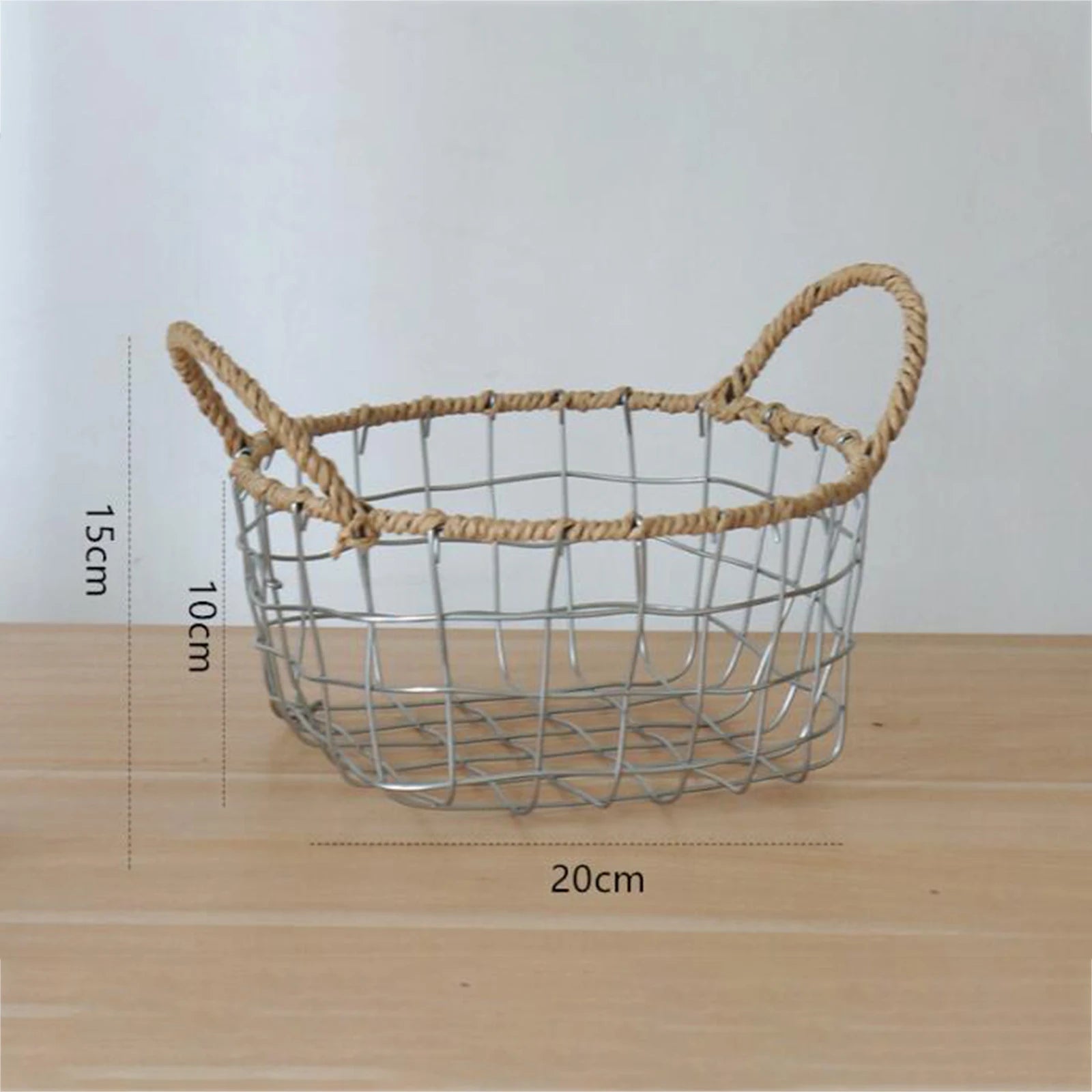 Complete view of the round woven metal wire storage basket with handles, illustrating its size and versatility in a Scandinavian design. Size: 20×20×10 cm.