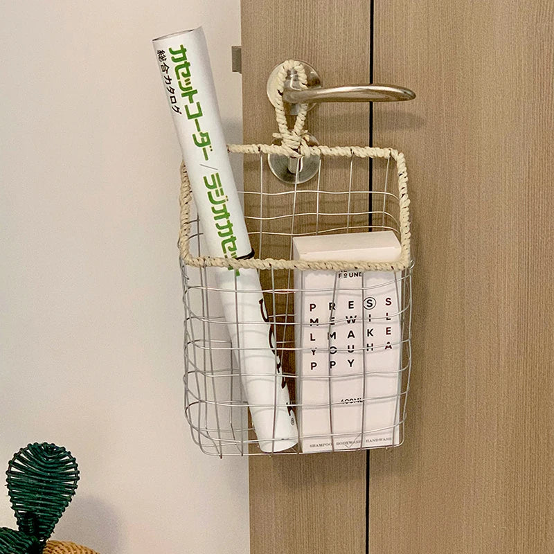 Scandinavian style woven metal wire storage basket on hallway hook, organizing daily use items, blending functionality and aesthetics.