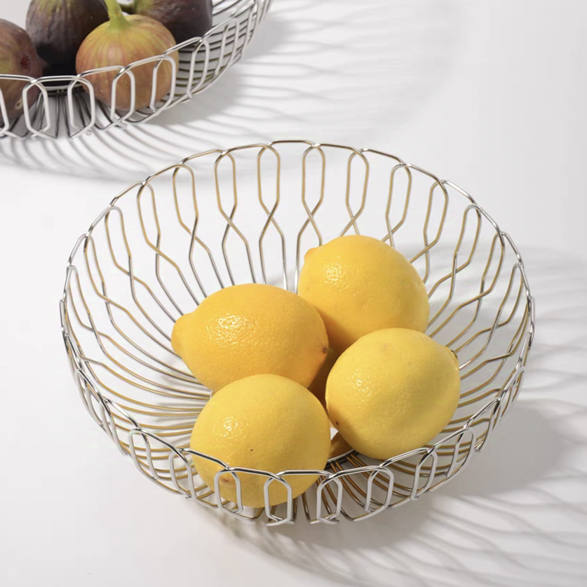 Stainless steel basket filled with lemons, combining functionality and modern aesthetics for kitchen storage.