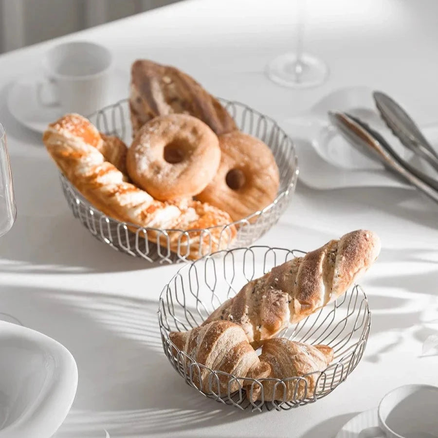 A bread basket made from polished stainless steel, offering a modern, stylish way to serve bread in your home.